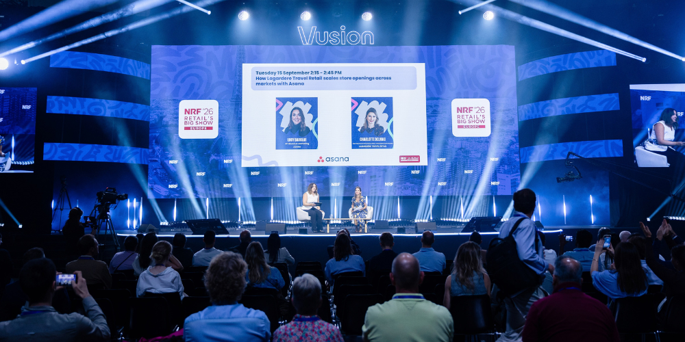 Conference stage at NRF 2026: Retail’s Big Show Europe, with two speakers on stage in front of the audience. Cette personnalité vous plaît-elle ?