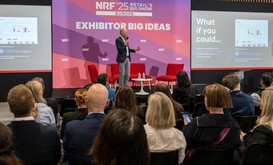 Homme tenant un micro devant un écran avec les mots Exhibitor Big Ideas