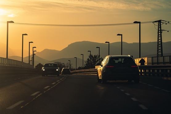 Voitures sur une route au coucher de soleil
